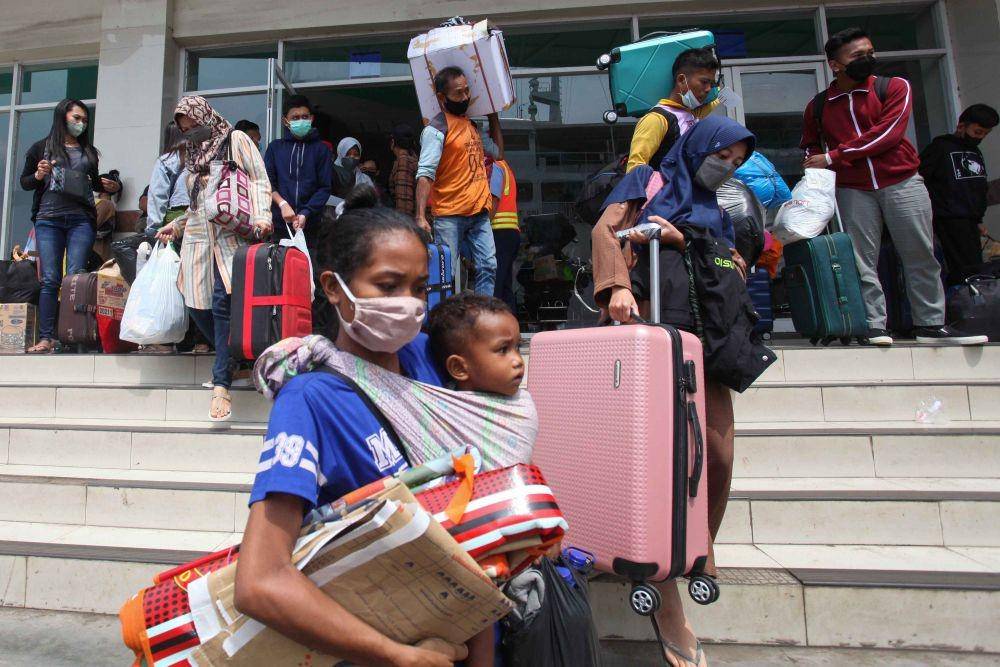 Penumpang membawa barang bawaannya berjalan menuju Kapal Motor Kirana III di Pelabuhan Tanjung Perak Surabaya, Jawa Timur, Rabu (27/4/2022). (ANTARA FOTO/Didik Suhartono)