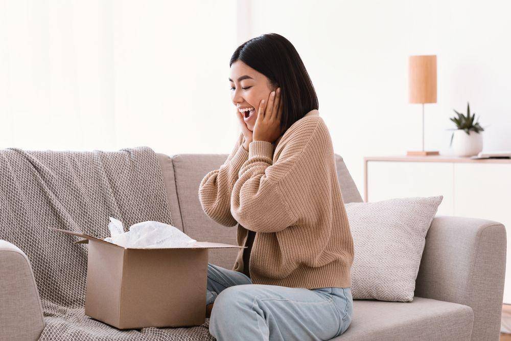 Millennial sedang membuka paket (Shutterstock/Prostock-studio)