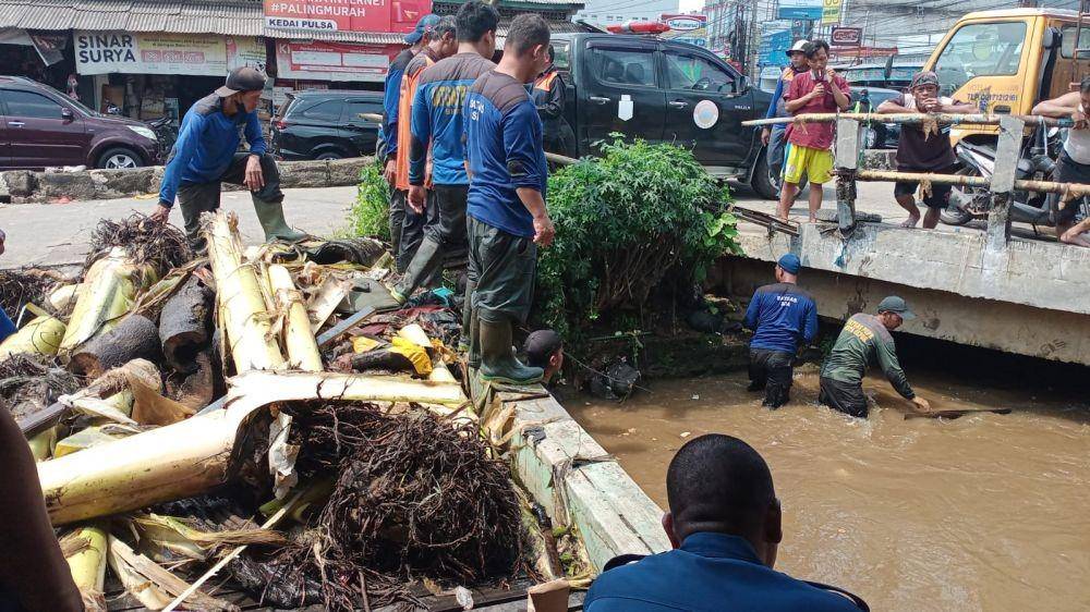 Satgas SDA DPUPR Kota Depok membersihkan sampah dan batang pohon yang tersumbat di bawah jembatan simpang Mampang, Kecamatan Pancoran Mas, Kota Depok. (Dokumen DPUPR)