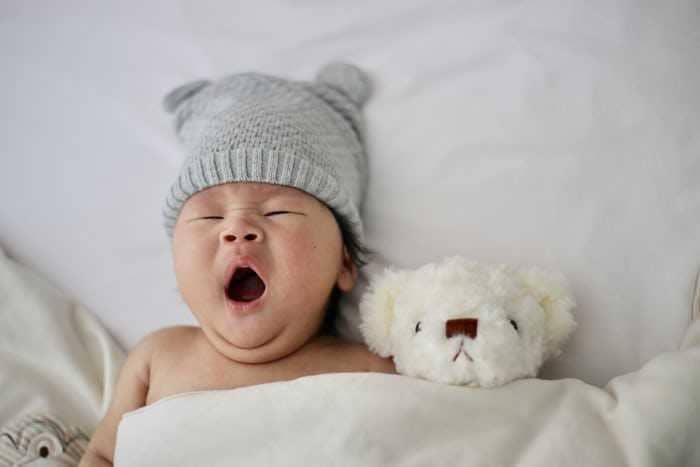 Ilustrasi bayi mengantuk dengan ekspresi lelah, menggambarkan waktu istirahat dan kebutuhan tidur yang cukup.