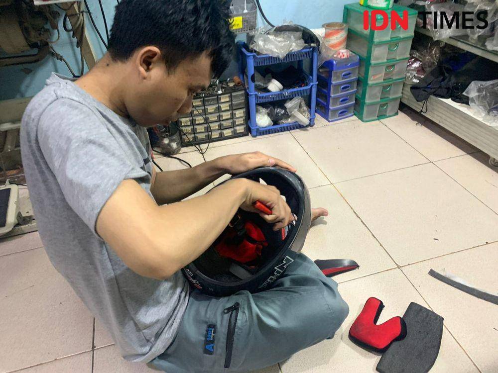 Ramdan dari Bengkel Helm sedang memperbaiki busa helm pelanggan (IDN Times/Fadhliansyah)
