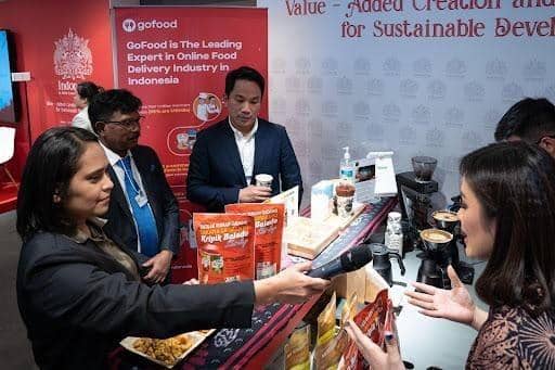 Menkominfo RI, Johnny G. Plate, bersama CEO GoTo Group, Andre Soelistyo dan Head of Marketing & PR Kripik Balado Shirley, Vallencia Melvinsy saat sedang memperkenalkan keripik singkong pedas khas Padang kepada jurnalis internasional (Dok. Gojek)