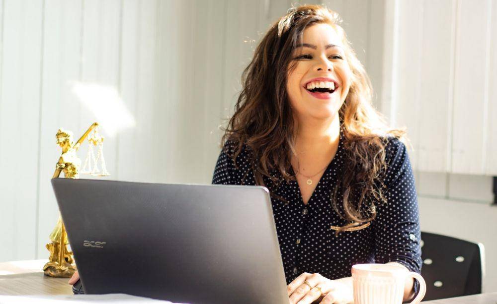 ilustrasi wanita tertawa di depan laptop (unsplash.com/mateus campos)