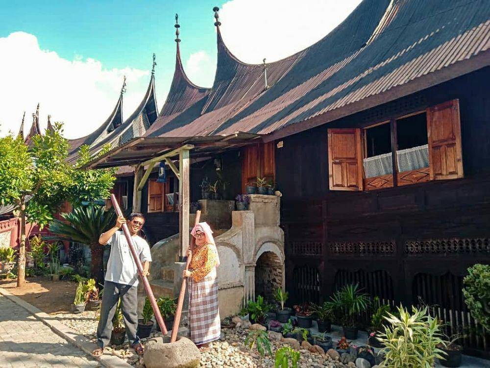 potret menumbuk padi di depan Rumah Gadang (instagram.com/@__imnining)