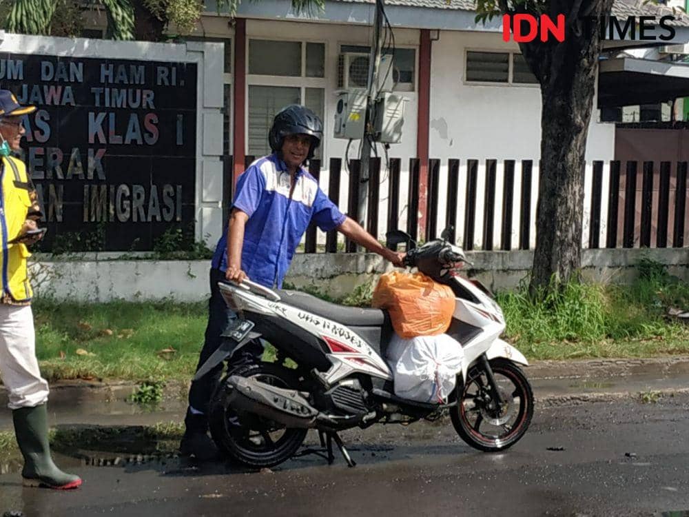 Sepeda motor salah seorang pengendara yang mogok setelah menerjang banjir rob di Kalimas Surabaya, Selasa (14/6/2022). (IDN Times/Khusnul Hasana)