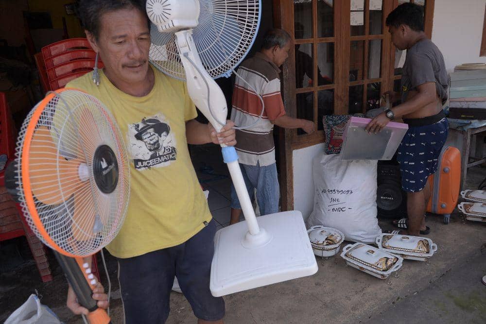 Warga sibuk mengevakuasi barang-barang dari rumah yang terdampak abrasi pesisir Amurang, Minahasa Selatan, Kamis (16/6/2022). IDNTimes/Ungke Pepotoh/bt