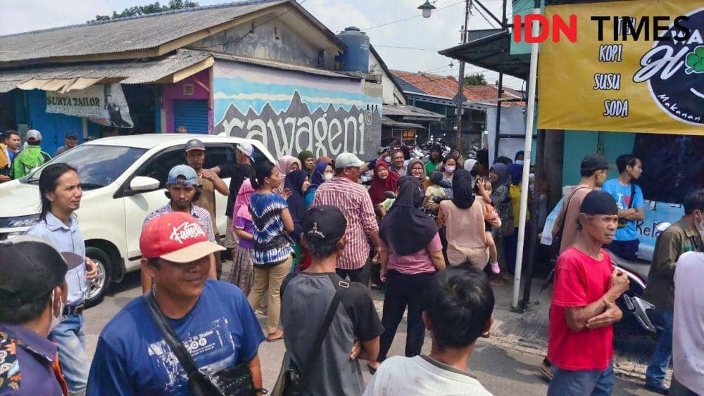 Sejumlah warga berkumpul menunggu keputusan pertemuan antara warga dan PT KAI terkait pembukaan kembali palang pintu manual perlintasan KRL Rawa Geni, Kecamatan Cipayung, Kota Depok. (IDNTimes/Dicky)