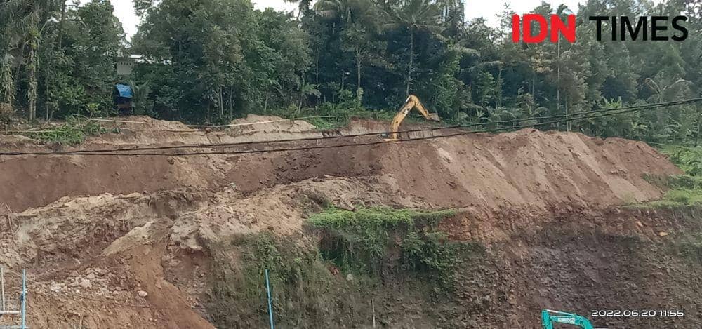 Sebuah alat berat mengeruk tanah di bagian tebing di proyek pembangunan Bendungan Meninting. (IDN Times/Muhammad Nasir)