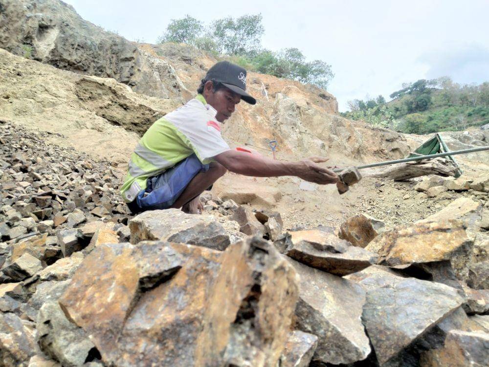 Foto M Saleh saat mengumpulkan pecahan batu. (IDN Times/Juliadin)