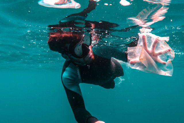 gambar seorang penyelam yang menemukan sampah plasti di laut (unsplash.com/Cristian Palmer)
