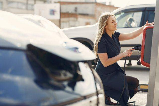 orang sedang charger mobil listrik 