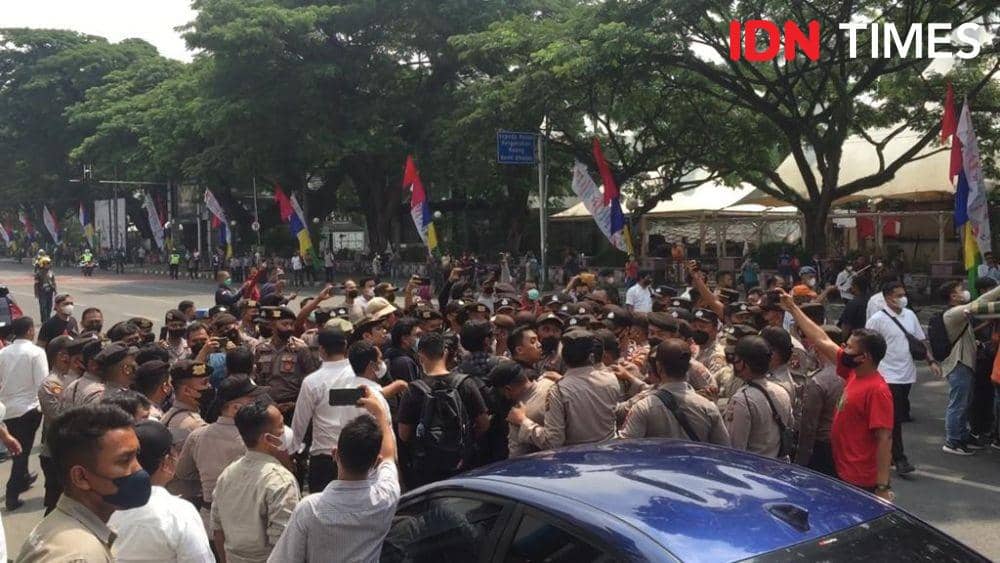 Kepolisian mengerubungi massa Aksi Kamisan Medan yang hendak menyampaikan aspirasi saat Presiden Jokowi melintas di Jalan Balai Kota, Medan, Kamis (7/7/2022). (IDN Times/Prayugo Utomo)