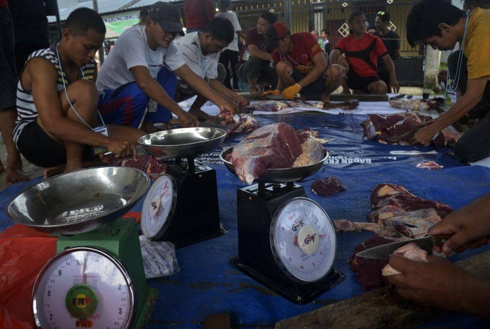 Warga mengiris daging hewan kurban yang akan dibagikan kepada warga di Perumahan Bumi Batara Mawang Permai, Kabupaten Gowa, Sulawesi Selatan, Minggu (10/7/2022). ANTARA FOTO/Abriawan Abhe/tom.