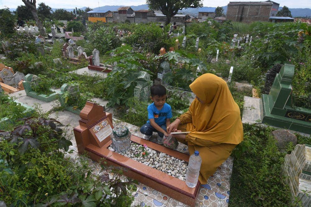 Foto udara warga menziarahi makam kerabatnya di TPU Pogego, Palu, Sulawesi Tengah, Minggu (10/7/2022). ANTARA FOTO/Mohamad Hamzah/tom.