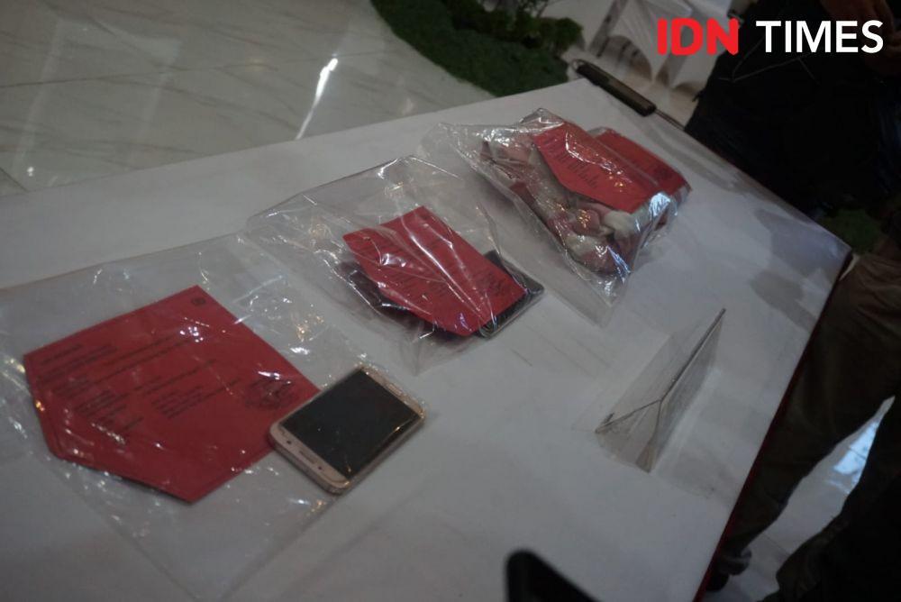 Barang bukti berupa ponsel pintar serta sarung bantal dan sprei sebagai petunjuk lokasi FAS saat melakukan aksinya. (IDN Times/Tunggul Damarjati)