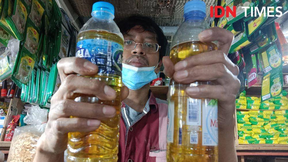Pedagang minyak goreng curah menunjukan botol isi setengah kilogram curah di lapaknya. (IDN Times/Fariz Fardianto)