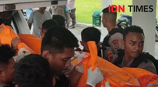 Personil Polres Mimika bersama personil Kodim 1710/ Mimika saat mengangkat jenazah dari dalam mobil jenazah untuk dimasukkan ke dalam ruang jenazah IDN Times/ Ricky Lodar