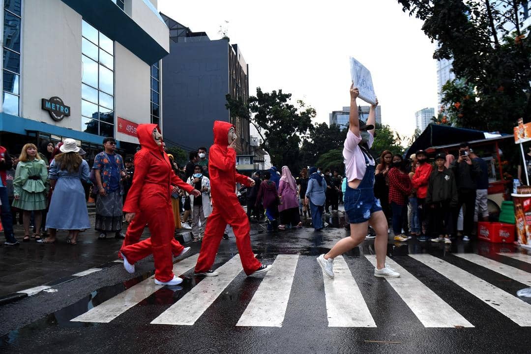 Warga berpose menampilkan busananya di atas zebra cross di kawasan Dukuh Atas, Jakarta, Sabtu (23/7).