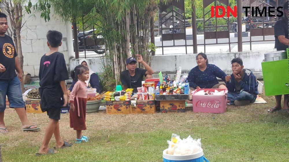 Seorang anak bermain di depan para pedagang asongan saat peringatan Hari Anak Nasional Tingkat Provinsi NTB di Taman Budaya Mataram, Kamis (28/7/2022). (IDN Times/Muhammad Nasir)