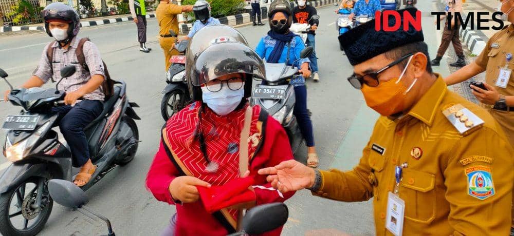 Wali Kota Balikpapan Kalimantan Timur (Kaltim) Rahmad Mas'ud membagikan bendera merah putih, Senin (1/8/2022). (IDN Times/Hilmansyah)