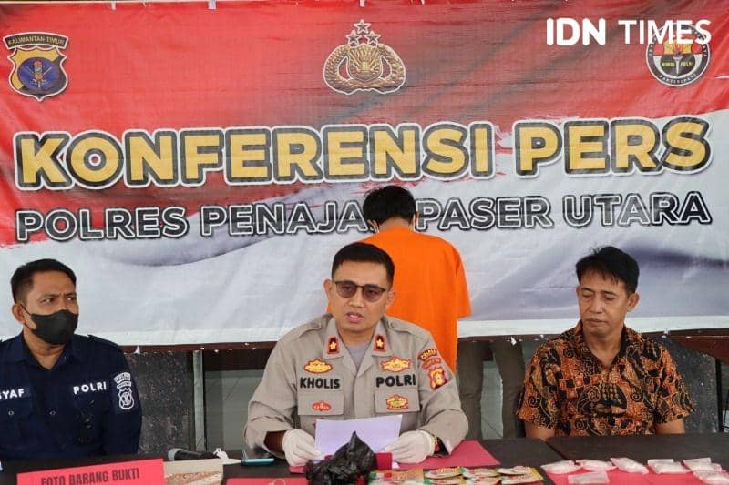 Wakapolres PPU, Kompol Nur Kholis saat menyampaikan rilis kepada wartawan dengan latar belakang tersangka HE (IDN Times/Ervan)