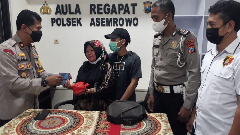 Polsek Asemrowo saat menyerahkan tas berisi uang Rp35 juta kepada pemilik. (Dok. Polsek Asemrowo)
