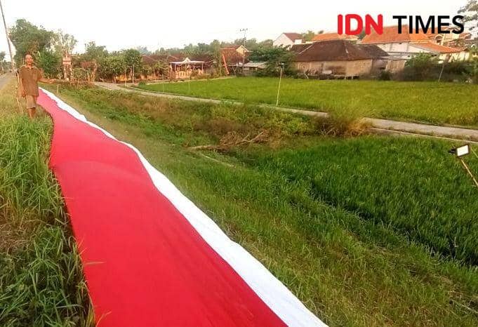 Bendera raksasa dibentangkan di tanggul Sungai Bengawan Solo Desa Mojoasem, Kecamatan Laren, Kabupaten Lamongan. IDN Times/Imron