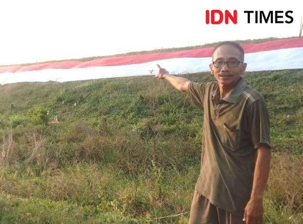 Patungan, Warga Lamongan Bentangkan Bendera 100 Meter di Bengawan Solo
