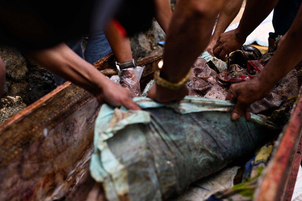 Keluarga membersihkan maayat pada acara ritual Ma'nene di Lembang Benteng Kado, Kecamatan Kapala Pitu, Kabupaten Toraja Utara, Sulawesi Selatan, Selasa (16/8/2022). IDN Times/Moh Niaz Sharief/bt