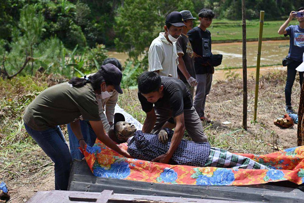 Mayat dimasukkan kembali ke dalam peti usai dibersihkan dan diganti pakaiannya pada acara ritual Manene di Desa Pangala Utara, Kecamatan Rindingalo, Kabupaten Toraja Utara, Sulawesi Selatan, Rabu (17/8/2022). IDN Times/Moh Niaz Sharief/bt