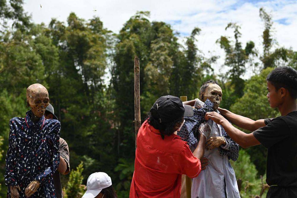 Sejumlah keluarga mengganti pakaian mayat pada acara ritual Ma'nene di Desa Pangala' Utara, Kecamatan Rindingallo, Kabupaten Toraja Utara, Sulawesi Selatan, Rabu (17/8/2022). IDN Times/Moh Niaz Sharief/bt