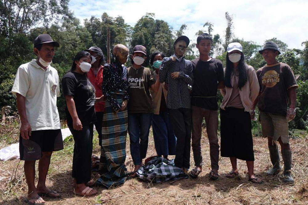 Sejumlah keluarga berfoto bersama usai mengganti pakaian mayat pada acara ritual Ma'nene di Desa Pangala Utara, Kecamatan Rindingalo, Kabupaten Toraja Utara, Sulawesi Selatan, Rabu (17/8/2022). Moh Niaz Sharief/bt