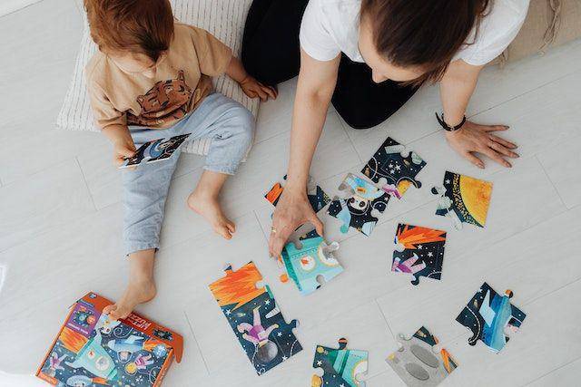 ilustrasi seorang ibu sedang bermain puzzle dengan anaknya (Pexels.com/Karolina Grabowska)