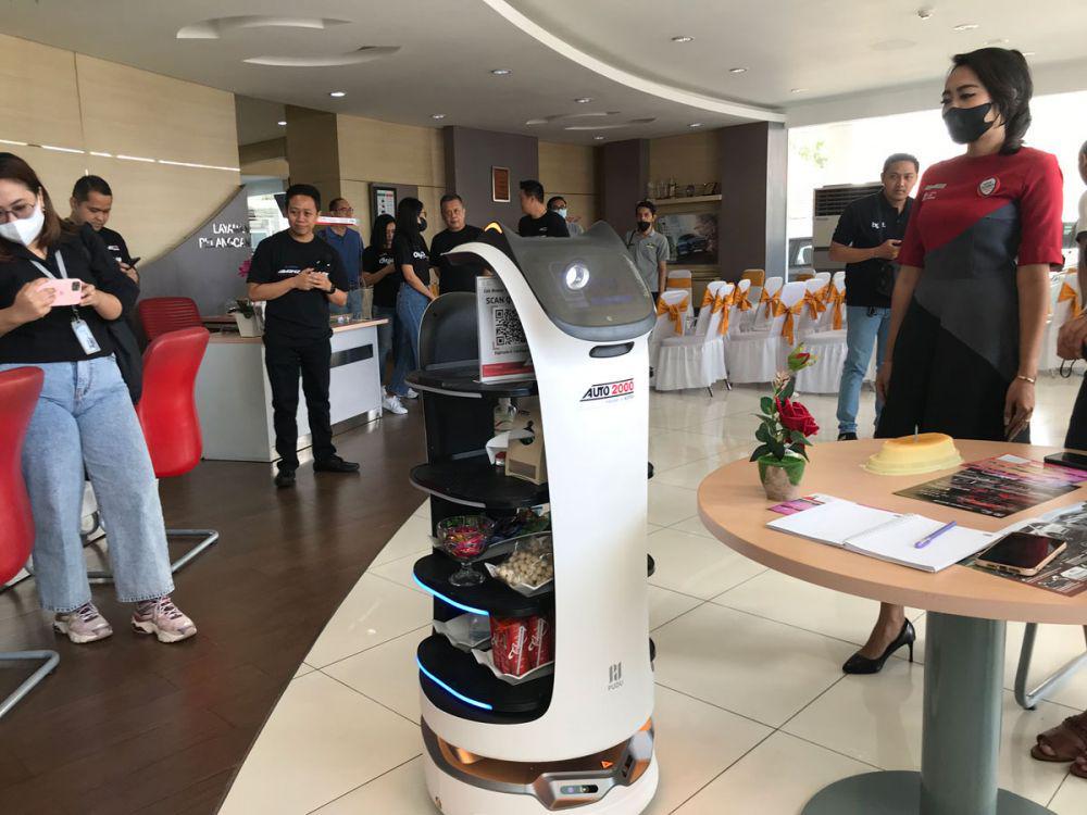 Robot Bella mengantarkan kue ulang tahun kepada customer yang berulang tahun. (dok. pribadi/Ari Budiadnyana)