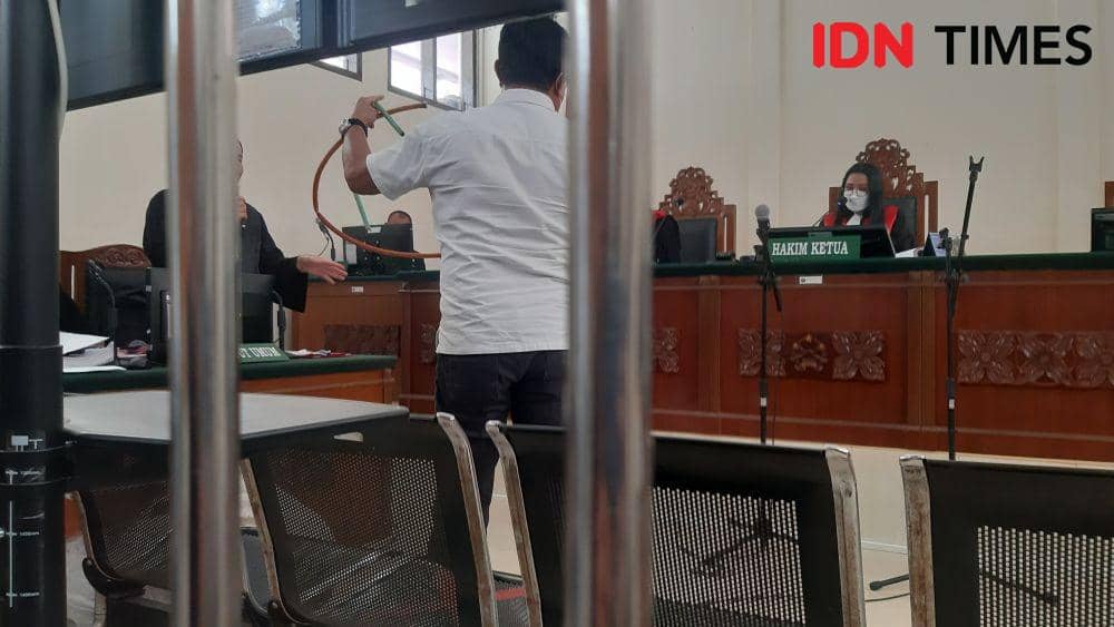 Saksi pelapor dari pihak kepolisian menunjukan selang yang diduga digunakan untuk menganiaya korban (penghuni kerangkeng). (IDN Times/ Bambang Suhandoko)
