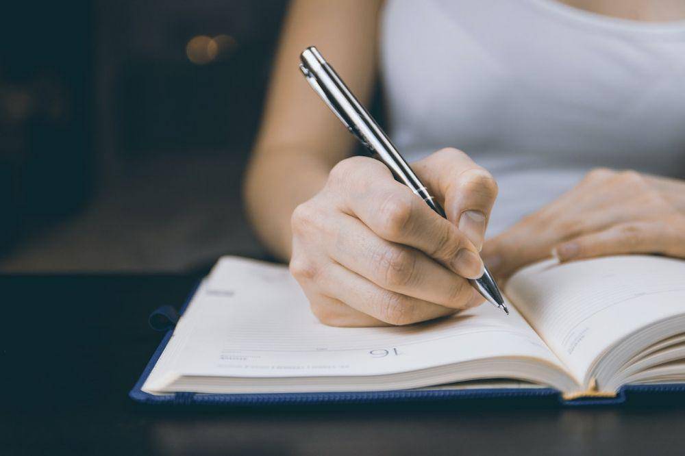 Ilustrasi sedang menulis buku (pexels.com/JESHOOTS.com)