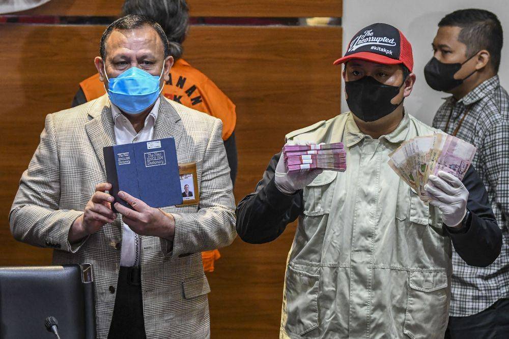 Ketua KPK Firli Bahuri (kiri) bersama Petugas KPK menunjukkan barang bukti saat konferensi pers terkait operasi tangkap tangan (OTT) perkara suap di Mahkamah Agung di gedung KPK, Jakarta, Jumat (23/9/2022). (ANTARA FOTO/Galih Pradipta)