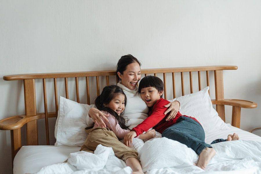 ilustrasi ibu dan dua anak di atas kasur (pexels.com/Ketut Subiyanto)