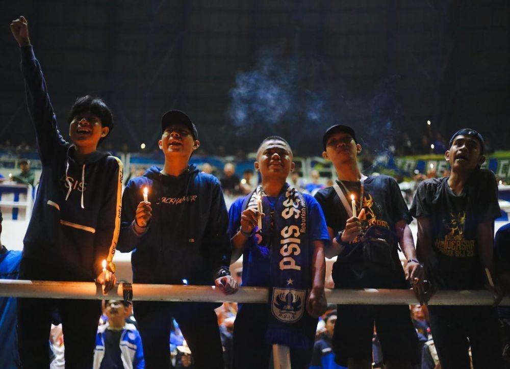 Para suporter PSIS Semarang melakukan aksi solidaritas dengan menyalakan lilin dan berdoa bersama di Stadion Jatidiri Semarang, Minggu (2/10/2022) malam. (Instagram/@panserbiru2001)