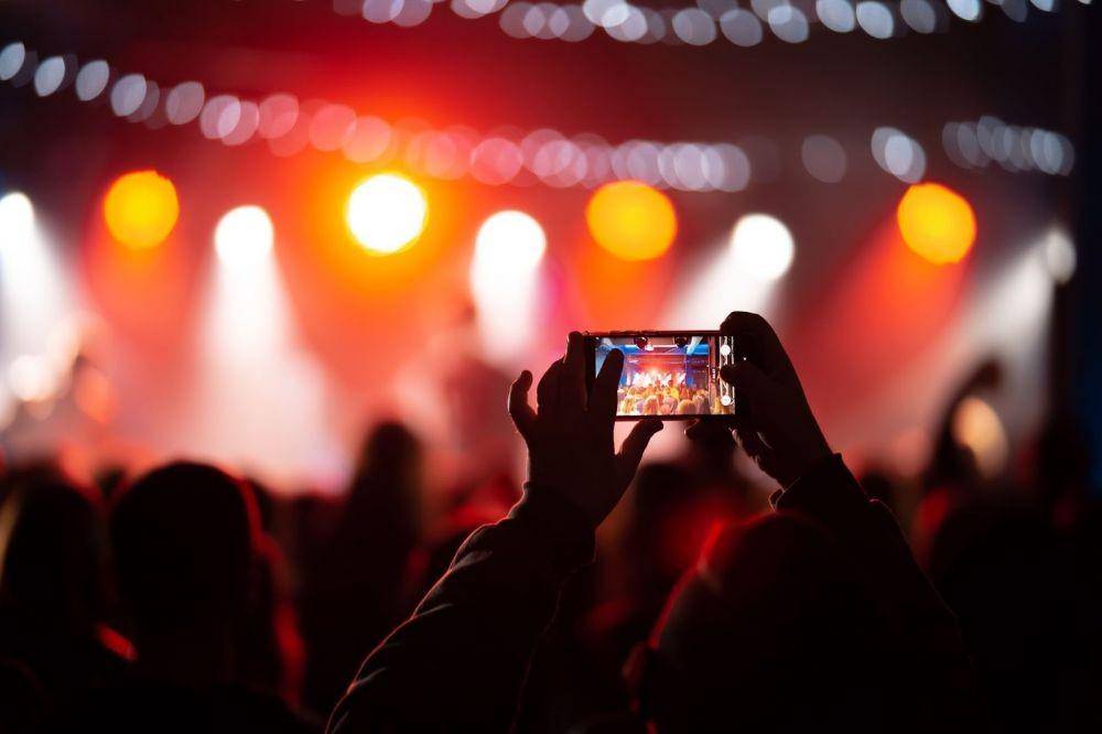 Nonton konser lewat HP (Freepik/teksomolika)
