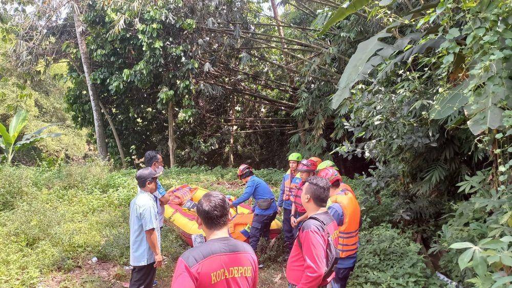 Petugas DPKP KOta Depok menyiapkan perahu karet untuk menyusuri sungai Ciliwung mencari korban hanyut. (Istimewa)