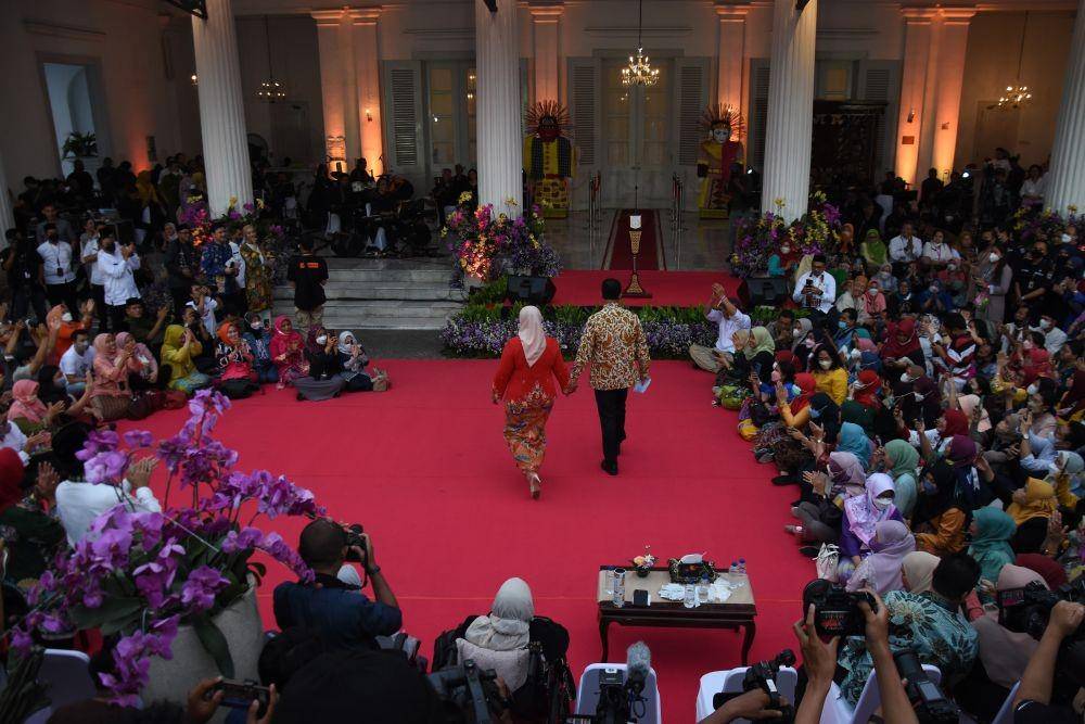 Gubernur DKI Jakarta Anies Baswedan (kanan) bersama isteri Fery Farhati (kiri) berjalan menuju podium untuk memberikan pidato perpisahan kepada para Aparatur Sipil Negara (ASN) di Balai Kota DKI Jakarta, Jumat (14/10/2022). (ANTARA FOTO/Indrianto Eko Suwarso/tom)
