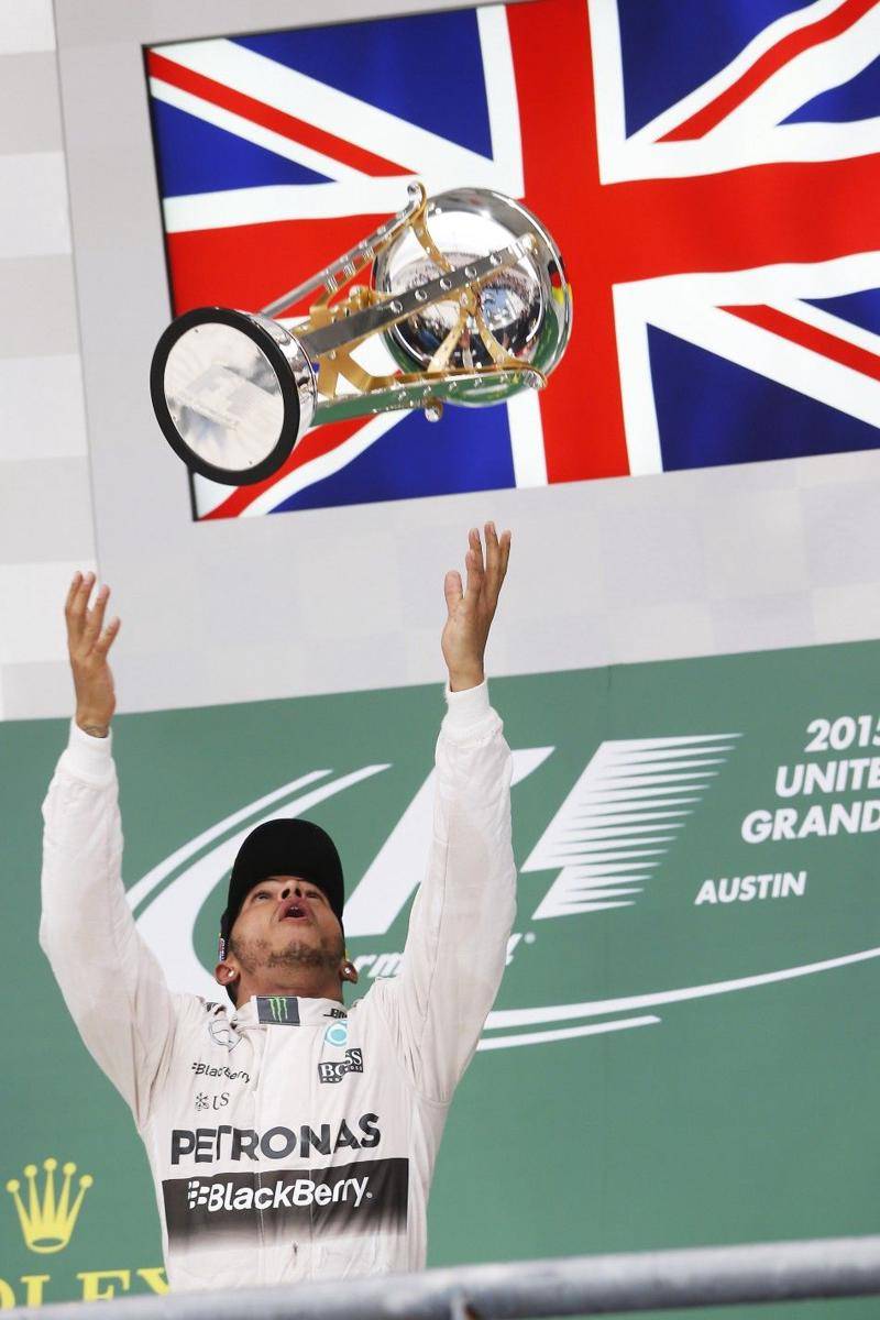 Lewis Hamilton melempar trofi juara pertama GP Amerika 2015. (fia.com)