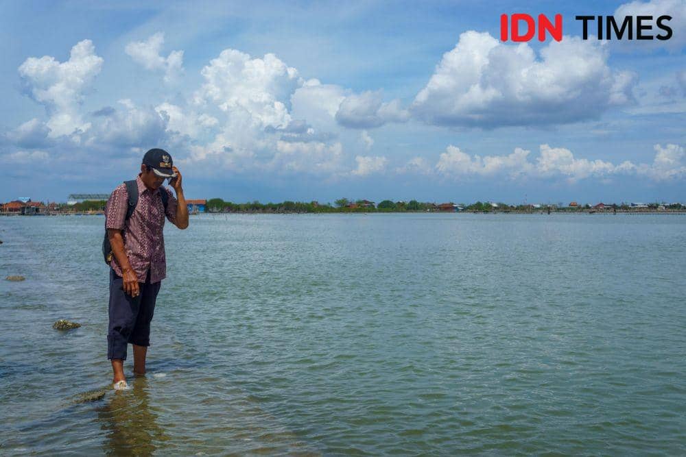 Suwarno, warga Demak Jawa Tengah, menelepon perangkat desa setempat untuk melaporkan kondisi jalan yang rusak dan tenggelam karena abrasi banjir rob karena kemudahan akses jaringan telekomunikasi. (IDN Times/Dhana Kencana)