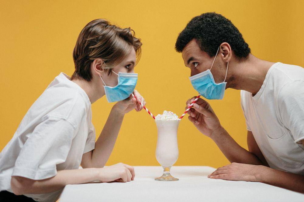 ilustrasi dua orang minum dengan masker (pexels.com/cottonbro)