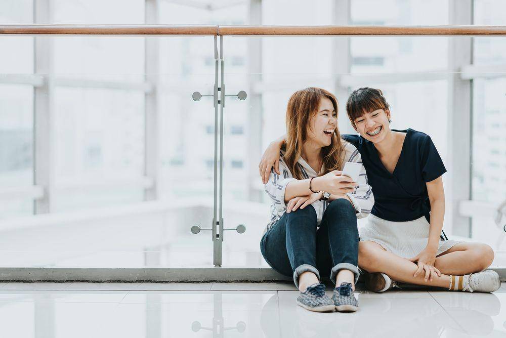 Dua wanita sedang tertawa bersama (Shutterstock/interstid)