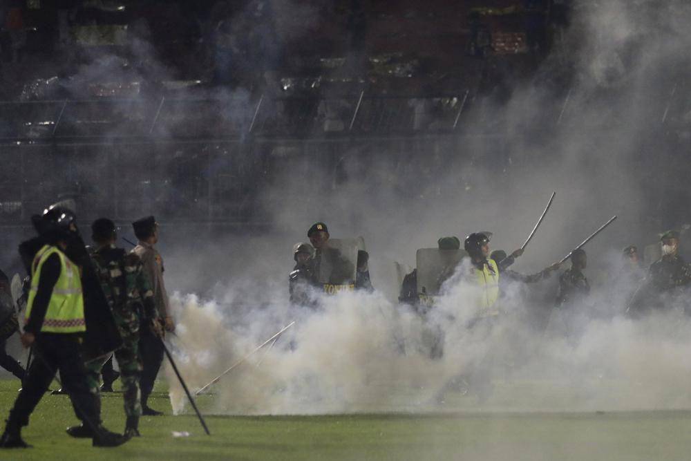 Polisi menembakkan gas air mata saat terjadi kerusuhan di Stadion Kanjuruhan, Malang, Sabtu (1/10/2022). (AP/Yudha Prabowo)