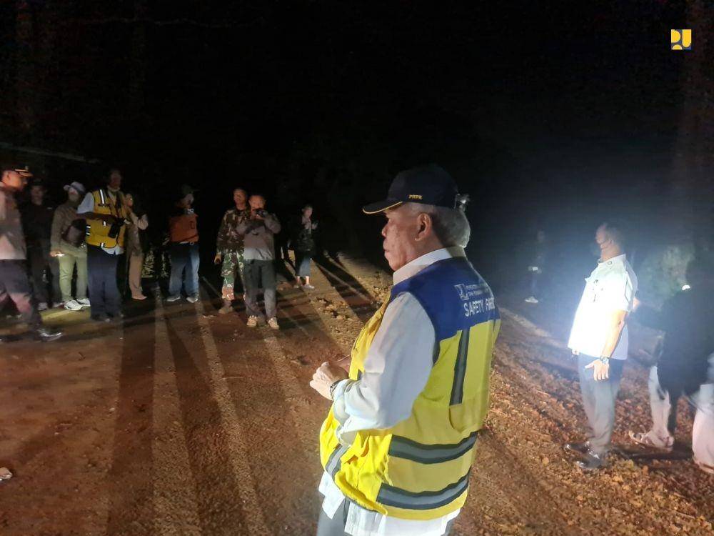 Excavator dan dump truck membersihkan pohon dan tanah longsoran yang menutup jalan. (dok. Kementerian PUPR)