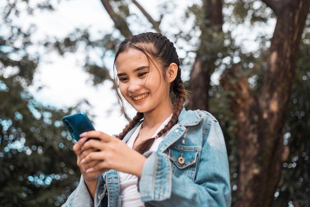 Ilustrasi seorang generasi Z sedang mencari informasi di HP (Shutterstock/MDV Edwards)