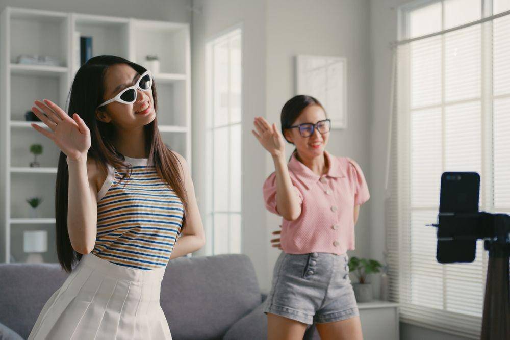 Para generasi Z sedang mencoba salah satu aplikasi di HP (Shutterstock/Nattakorn_Maneerat)